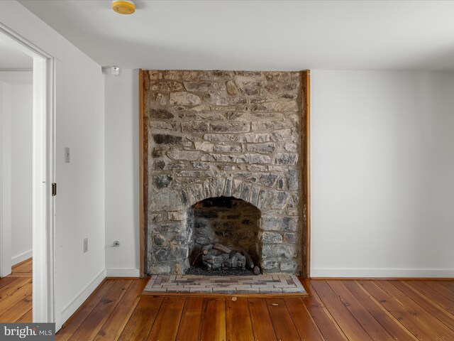 room details with a fireplace, baseboards, and wood finished floors