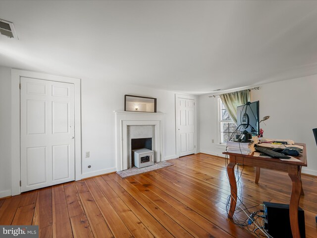 living room with visible vents, baseboards, and wood-type flooring