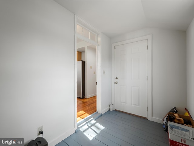 entrance foyer with baseboards, hardwood / wood-style floors, and vaulted ceiling