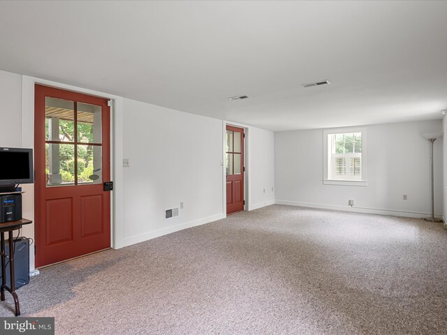 carpeted empty room featuring visible vents and baseboards