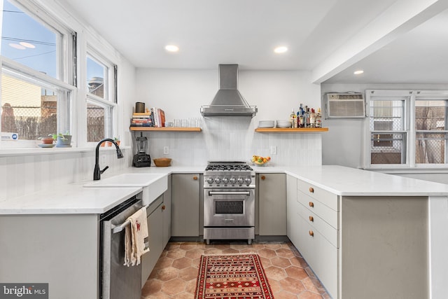 kitchen with a sink, stainless steel appliances, wall chimney range hood, and open shelves