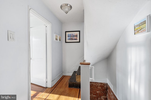 corridor featuring wood finished floors and baseboards