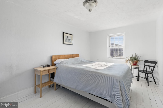 bedroom with hardwood / wood-style floors and baseboards