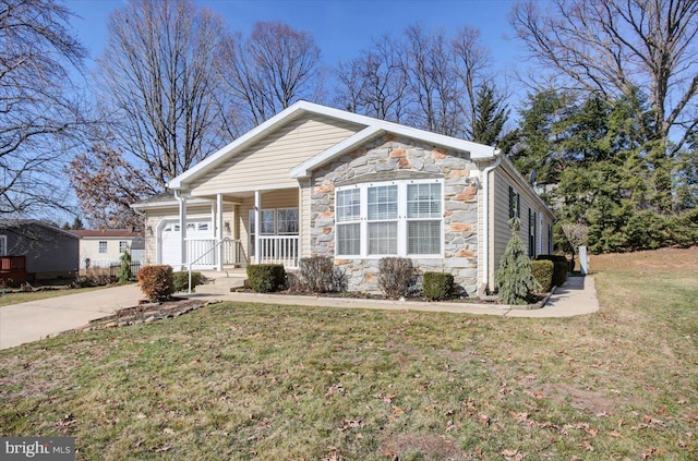 view of front facade with stone siding, an attached garage, a porch, and a front yard