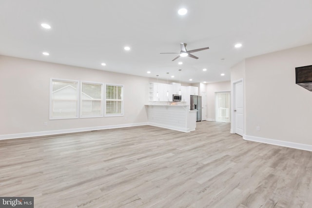 unfurnished living room with light wood-style flooring, recessed lighting, and baseboards