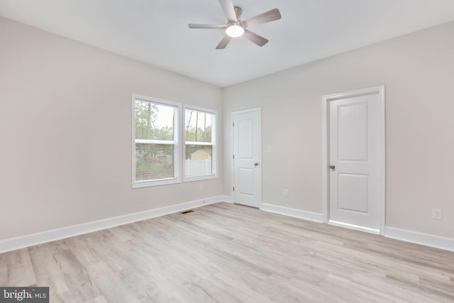 unfurnished bedroom with visible vents, light wood-style flooring, a ceiling fan, and baseboards