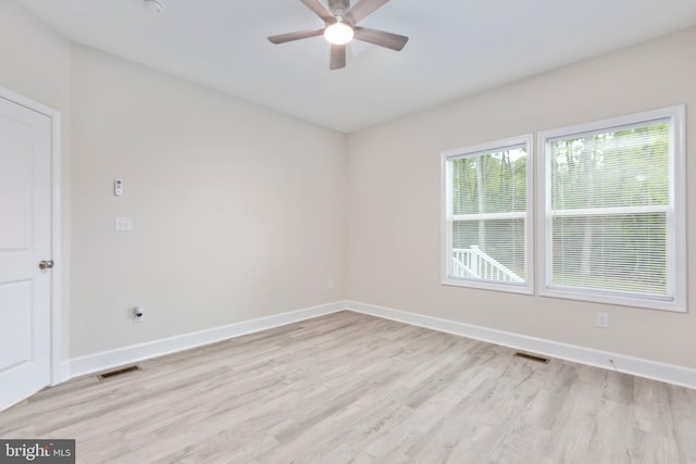 spare room with a ceiling fan, light wood-style flooring, baseboards, and visible vents