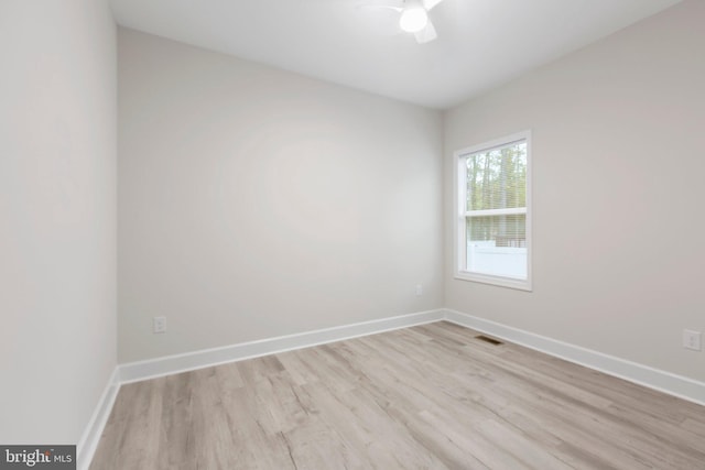 spare room with visible vents, baseboards, wood finished floors, and a ceiling fan