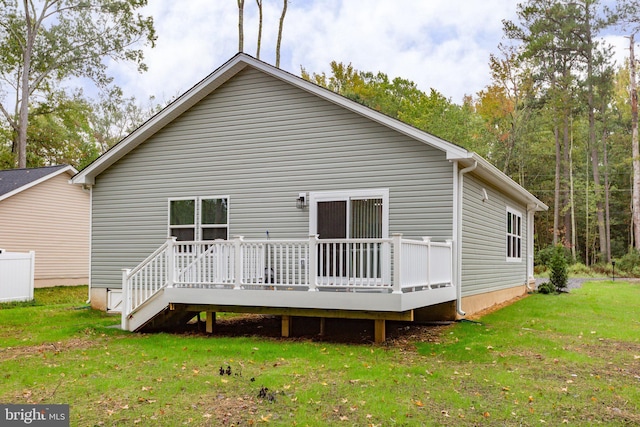 back of property featuring a wooden deck and a lawn