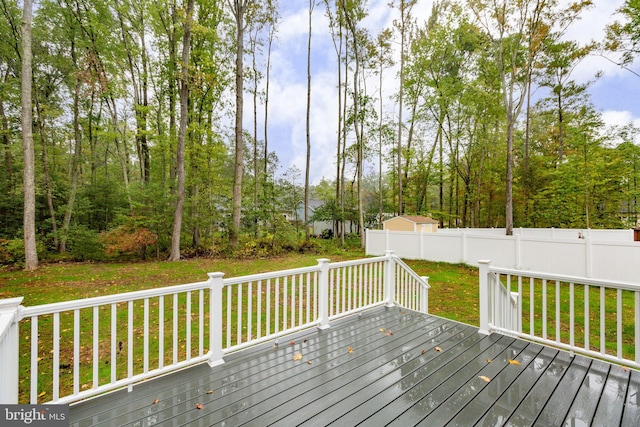 wooden terrace featuring a yard and fence