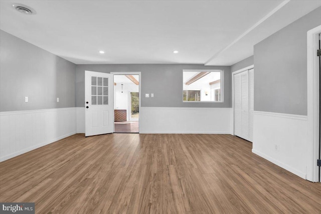 unfurnished room featuring recessed lighting, visible vents, wood finished floors, and a wainscoted wall