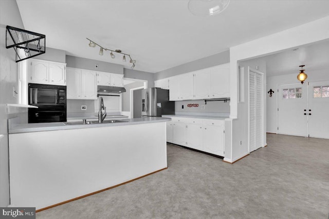 kitchen with under cabinet range hood, white cabinets, black appliances, and a sink