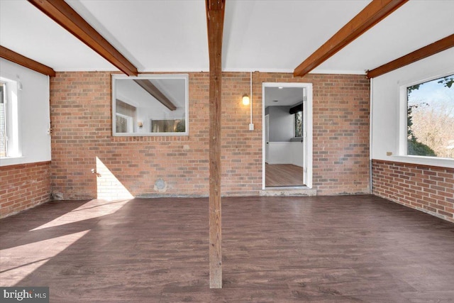 interior space featuring beam ceiling, brick wall, and wood finished floors