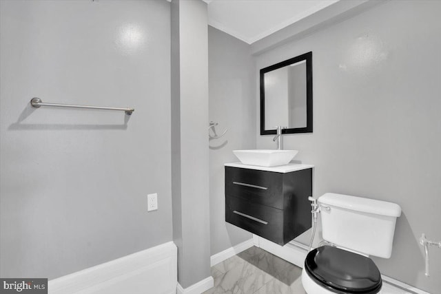 half bathroom featuring marble finish floor, toilet, vanity, and baseboards