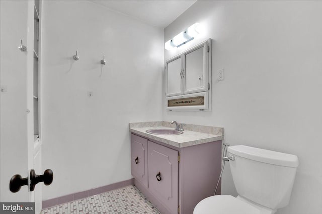 bathroom featuring baseboards, toilet, and vanity