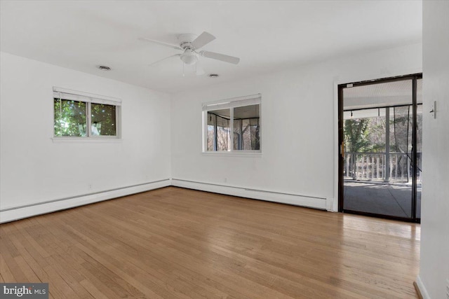 spare room featuring visible vents, a baseboard radiator, a ceiling fan, and wood finished floors