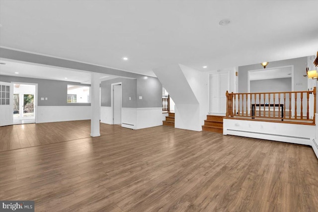 unfurnished living room featuring stairway, recessed lighting, wood finished floors, and baseboard heating