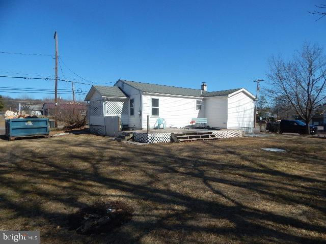 rear view of house with a yard and a wooden deck