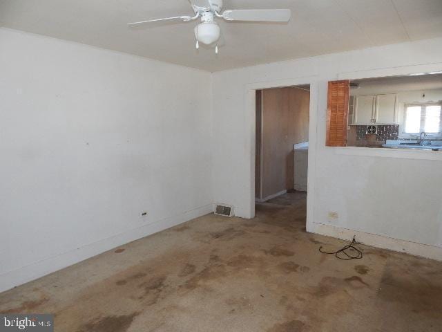 unfurnished living room featuring visible vents, baseboards, and ceiling fan