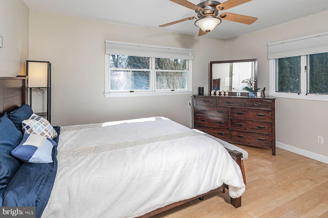 bedroom featuring baseboards, light wood-type flooring, and ceiling fan