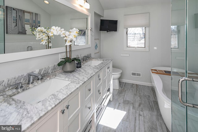 bathroom featuring visible vents, wood finished floors, lofted ceiling, and a sink