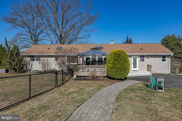 view of front of house featuring a gazebo, driveway, a front lawn, and fence