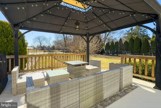 deck with a gazebo, an outdoor living space, and fence