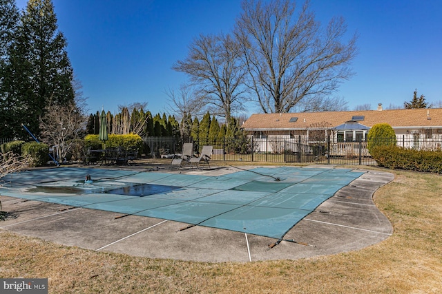 pool featuring a patio area, a yard, and fence