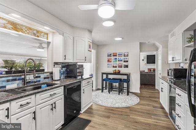 kitchen featuring white cabinetry, ceiling fan, and a sink