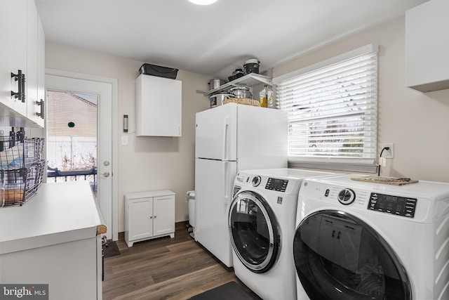 clothes washing area with dark wood finished floors, cabinet space, a wealth of natural light, and washing machine and clothes dryer