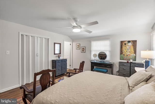 bedroom featuring wood finished floors, baseboards, ceiling fan, vaulted ceiling, and a closet