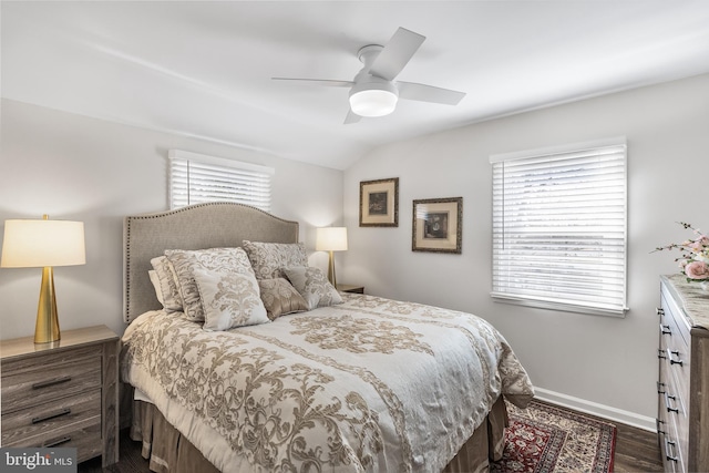 bedroom featuring ceiling fan, baseboards, lofted ceiling, and dark wood finished floors