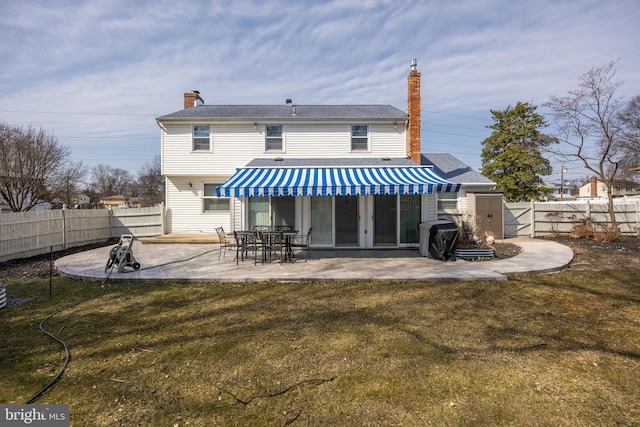 rear view of property featuring a patio, a lawn, and a fenced backyard