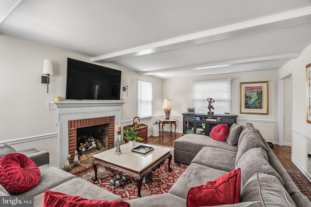 living area with a fireplace, beam ceiling, wood finished floors, and baseboards