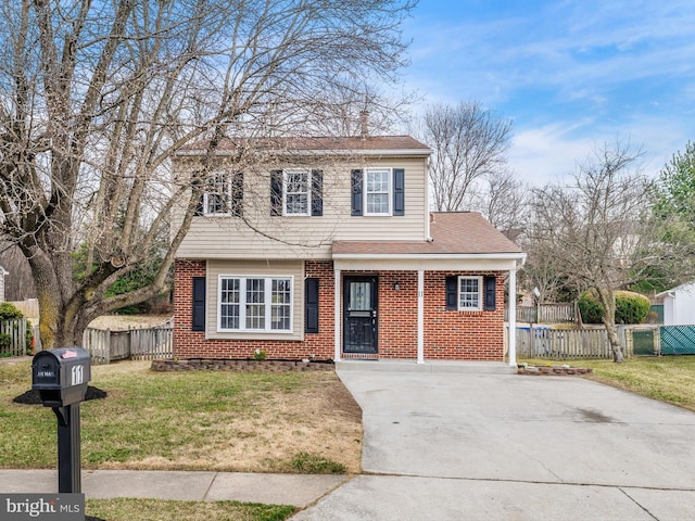 view of front facade with brick siding, a front lawn, fence, roof with shingles, and driveway