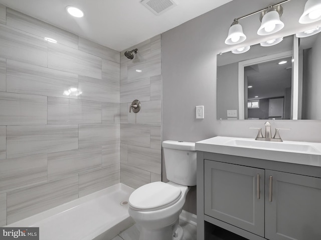 full bath featuring visible vents, toilet, vanity, and tiled shower