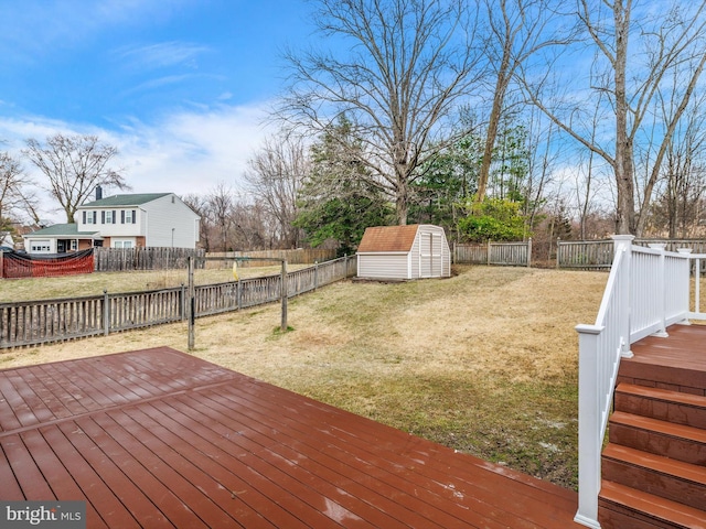 deck with an outdoor structure, a storage unit, a fenced backyard, and a lawn