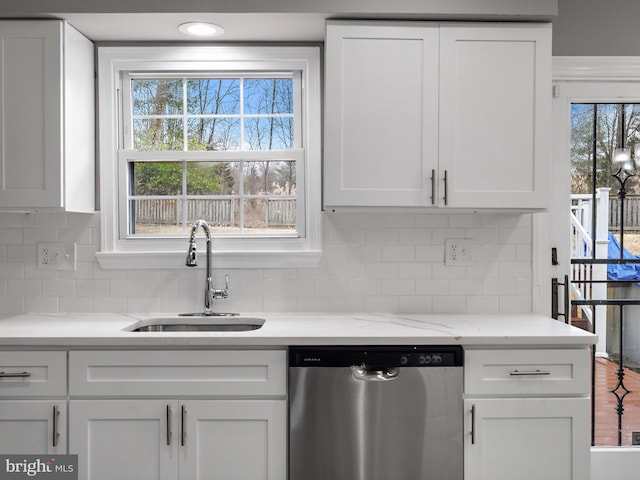 kitchen with a sink, tasteful backsplash, stainless steel dishwasher, white cabinetry, and light stone countertops