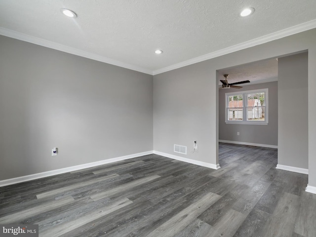 spare room with visible vents, baseboards, dark wood-type flooring, and ornamental molding