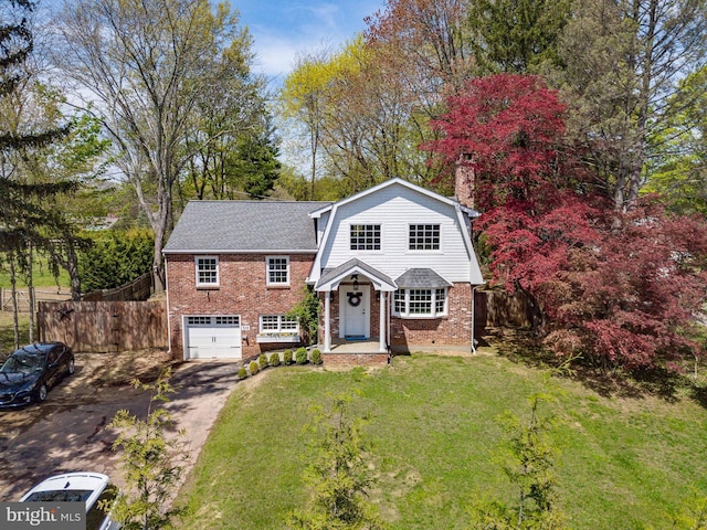 319 W Conestoga Rd, Devon, PA 19333 - view of front facade with a gambrel roof, a front lawn, aphalt driveway, fence, and brick siding