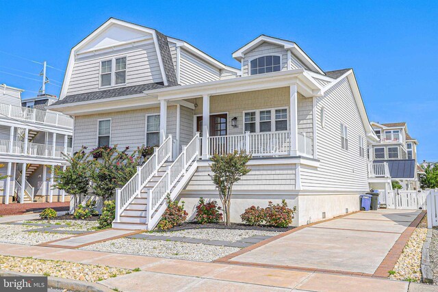 285 78th St, Avalon, NJ 08202 - view of front of home with covered porch, a shingled roof, a gambrel roof, stairway, and concrete driveway