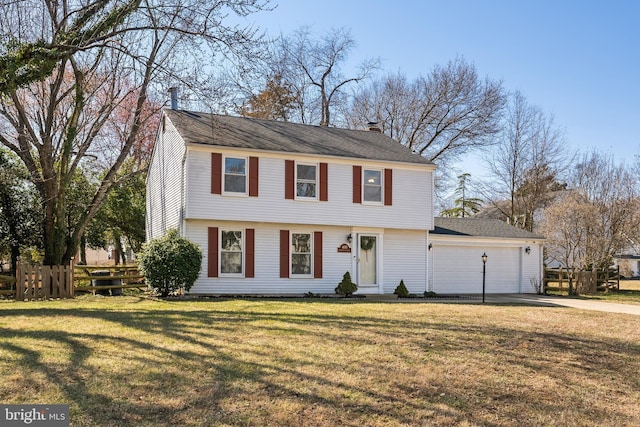 colonial home featuring driveway, fence, a front yard, a garage, and a chimney