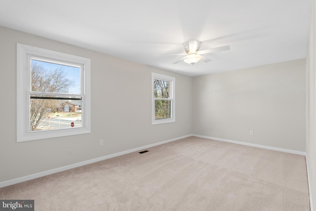 unfurnished room with visible vents, ceiling fan, baseboards, and carpet