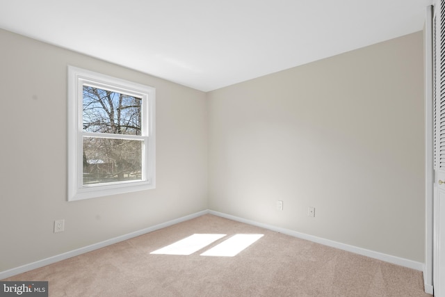 empty room featuring carpet flooring and baseboards