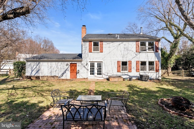 back of house featuring a patio, fence, a chimney, a fire pit, and a lawn