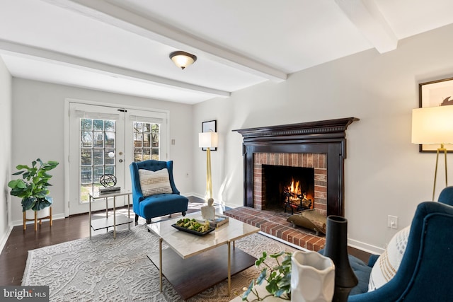 living area with beam ceiling, a brick fireplace, wood finished floors, and french doors