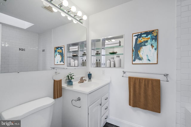 bathroom featuring visible vents, toilet, a skylight, and vanity