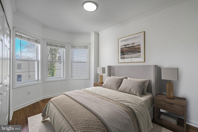 bedroom featuring crown molding, dark wood-style floors, and baseboards