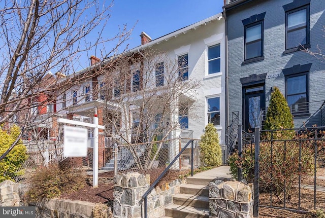 multi unit property featuring brick siding and a chimney