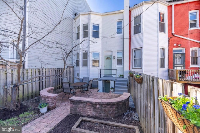 rear view of property featuring a fenced backyard and a patio area